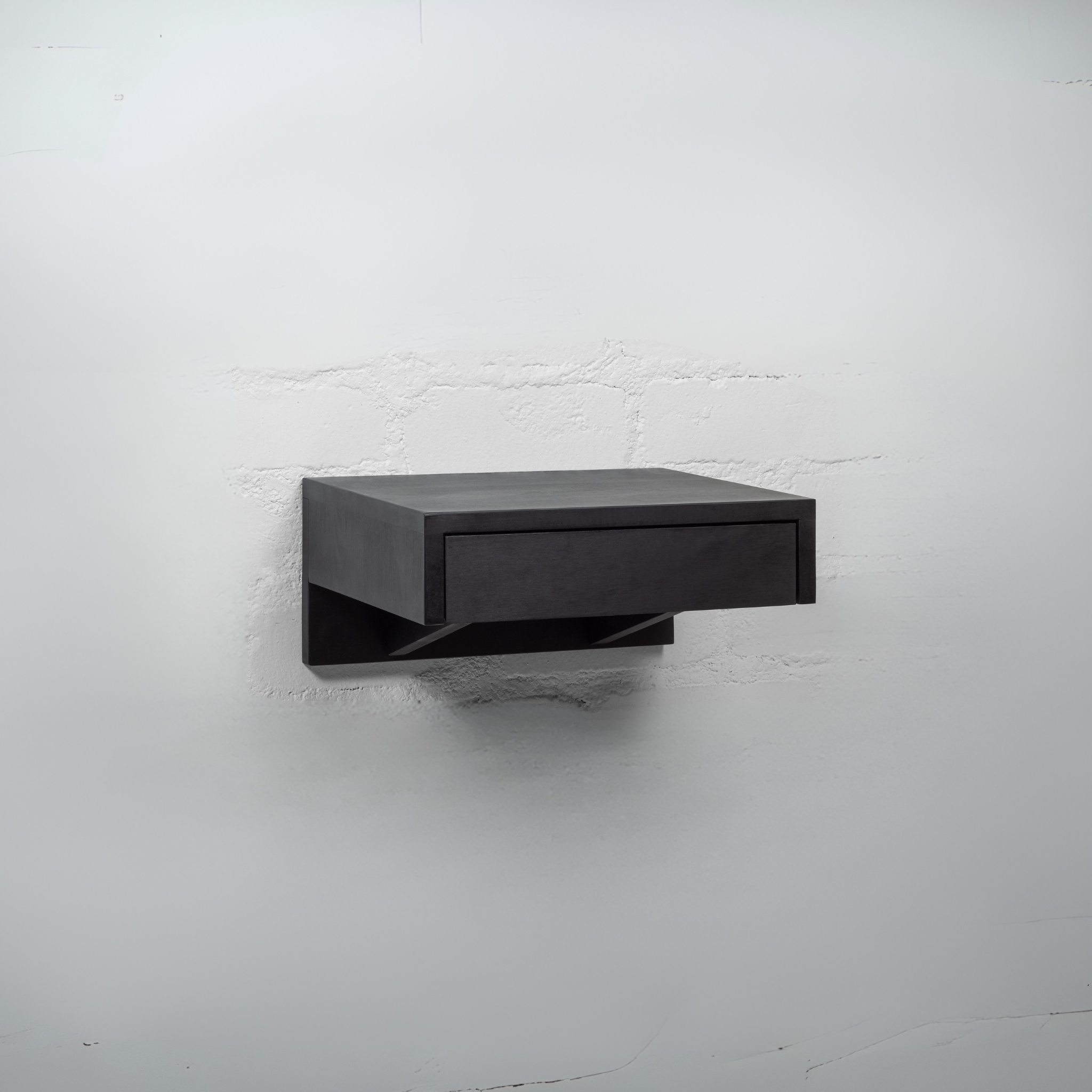A black wooden nightstand with an open drawer revealing spacious storage for organizing bedroom essentials