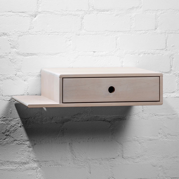 Bedside table featuring a white wooden finish and minimalist handle-free drawer design