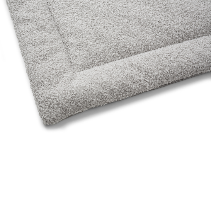 Close-up of a soft and durable gray bed with a textured surface for extra comfort.