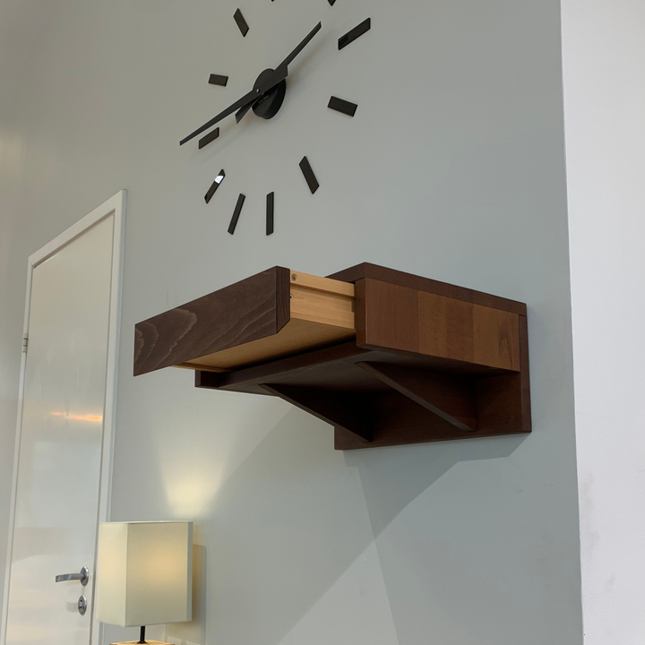 A sleek wooden nightstand attached to the wall, featuring a single drawer with a smooth finish