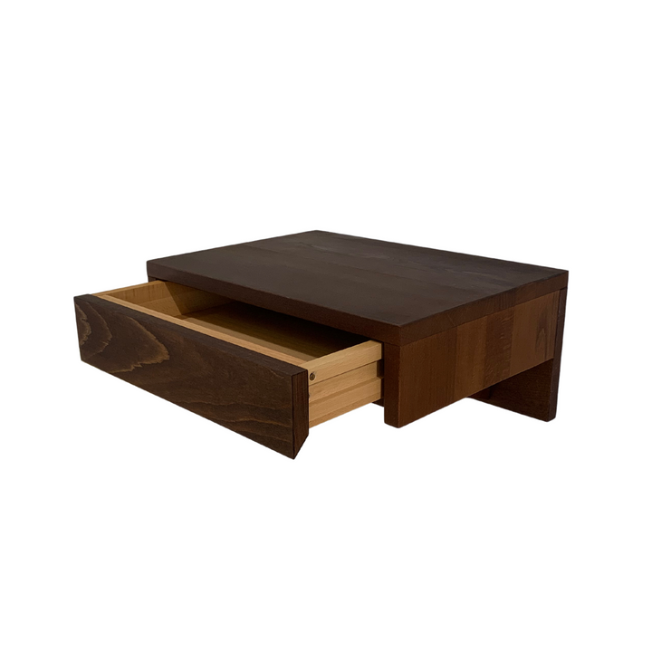 A modern bedside table with a drawer, mounted on the wall for a space-saving solution