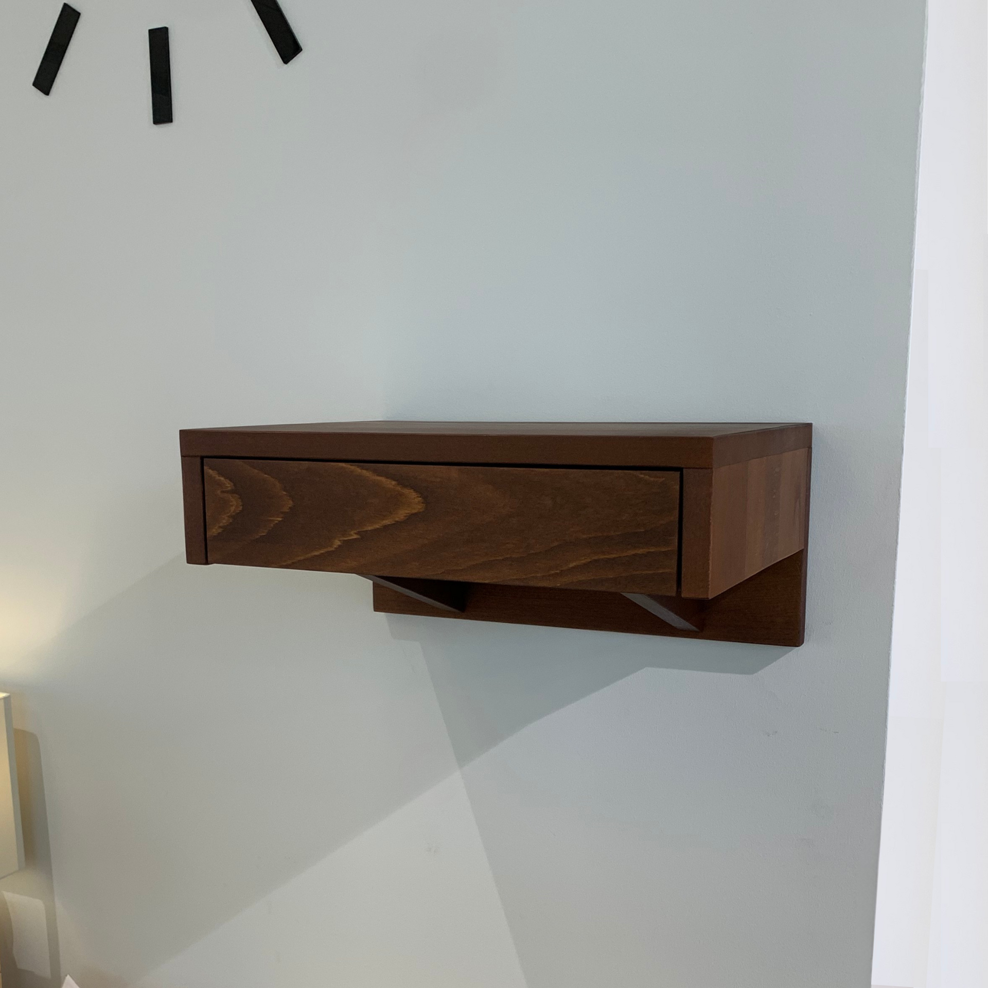 A wooden bedside table featuring a smooth drawer, seamlessly blending with modern bedroom interiors.