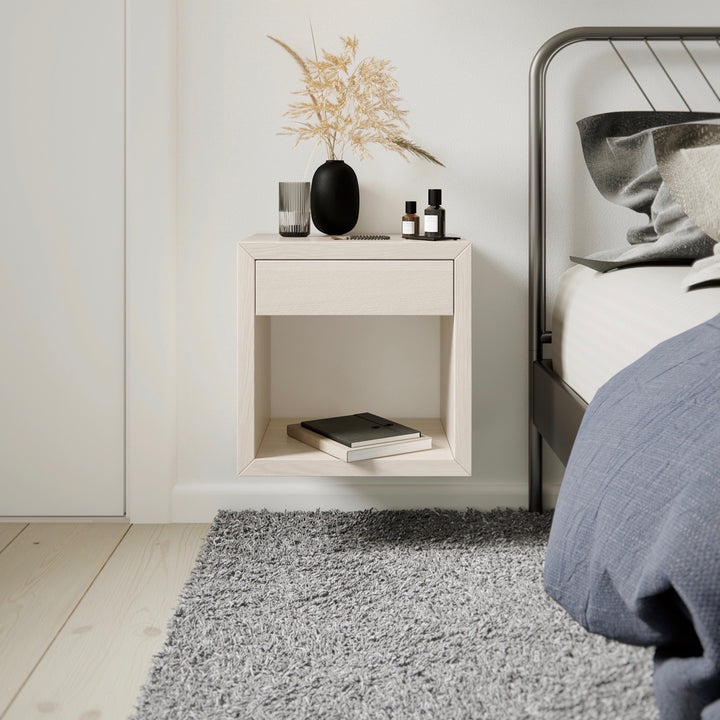 The small nightstand is finely crafted in solid birch wood with a white finish. With a minimal style it shows the beauty of the natural grain of the wood.