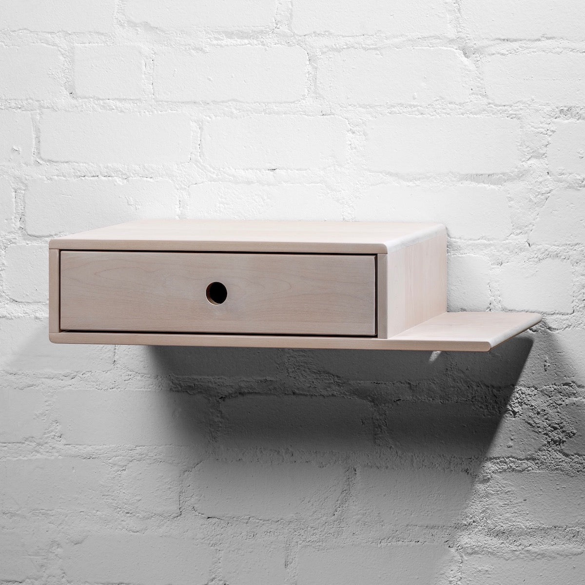 Wooden nightstand with a functional drawer, paired with an extended side shelf for additional storage