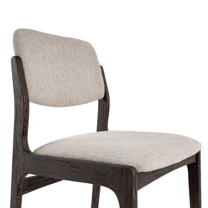 A modern dining chair with a dark brown wood frame and textured beige fabric upholstery on the seat and curved backrest, shown against a plain white background.