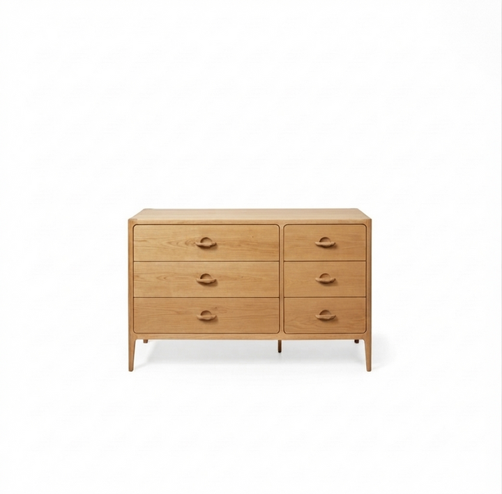 A mid-century modern wooden dresser with six drawers, featuring a natural oak finish and simple round metal pulls, set against a plain white background.