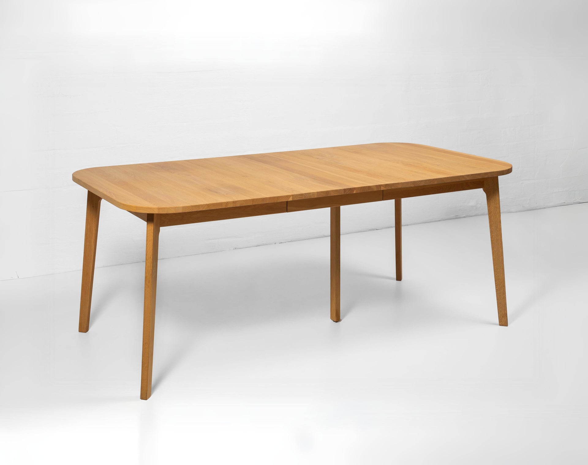 Handcrafted extendable oak dining table with warm wood tones and rustic texture