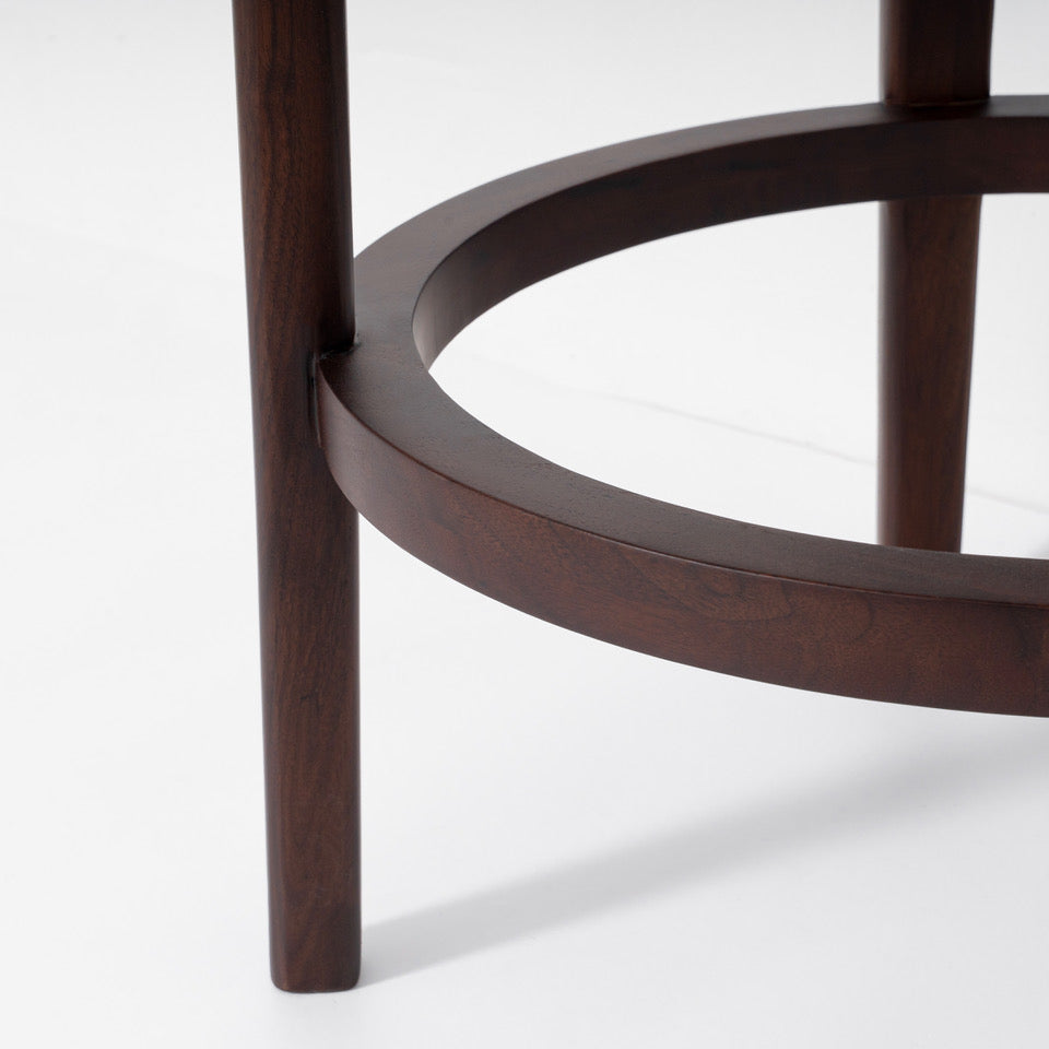 Close-up of a dark brown wooden table leg and circular lower shelf on a clean white background.