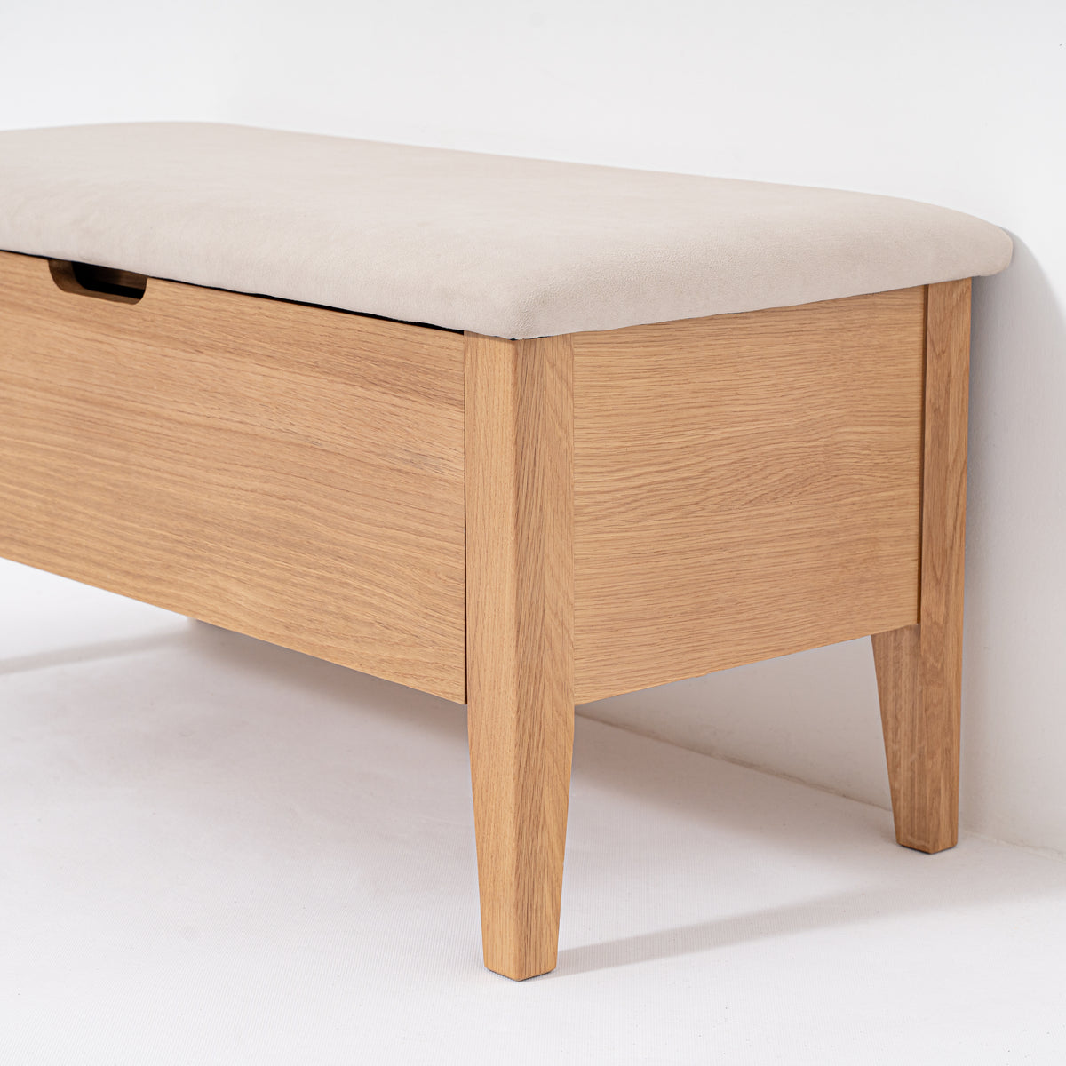 Wooden bench with a beige cushion on a white background