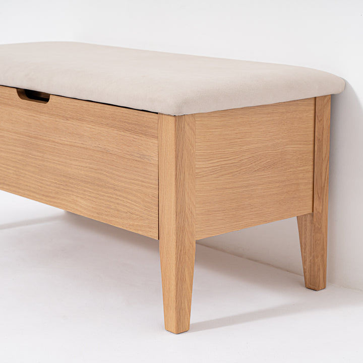 Wooden bench with a beige cushion on a white background
