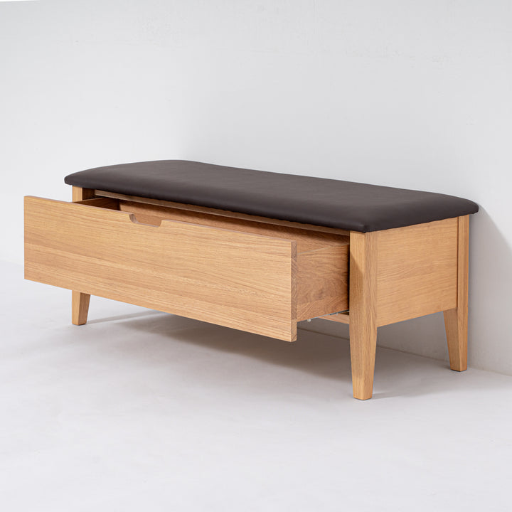 Wooden bench with a dark cushion on a white background
