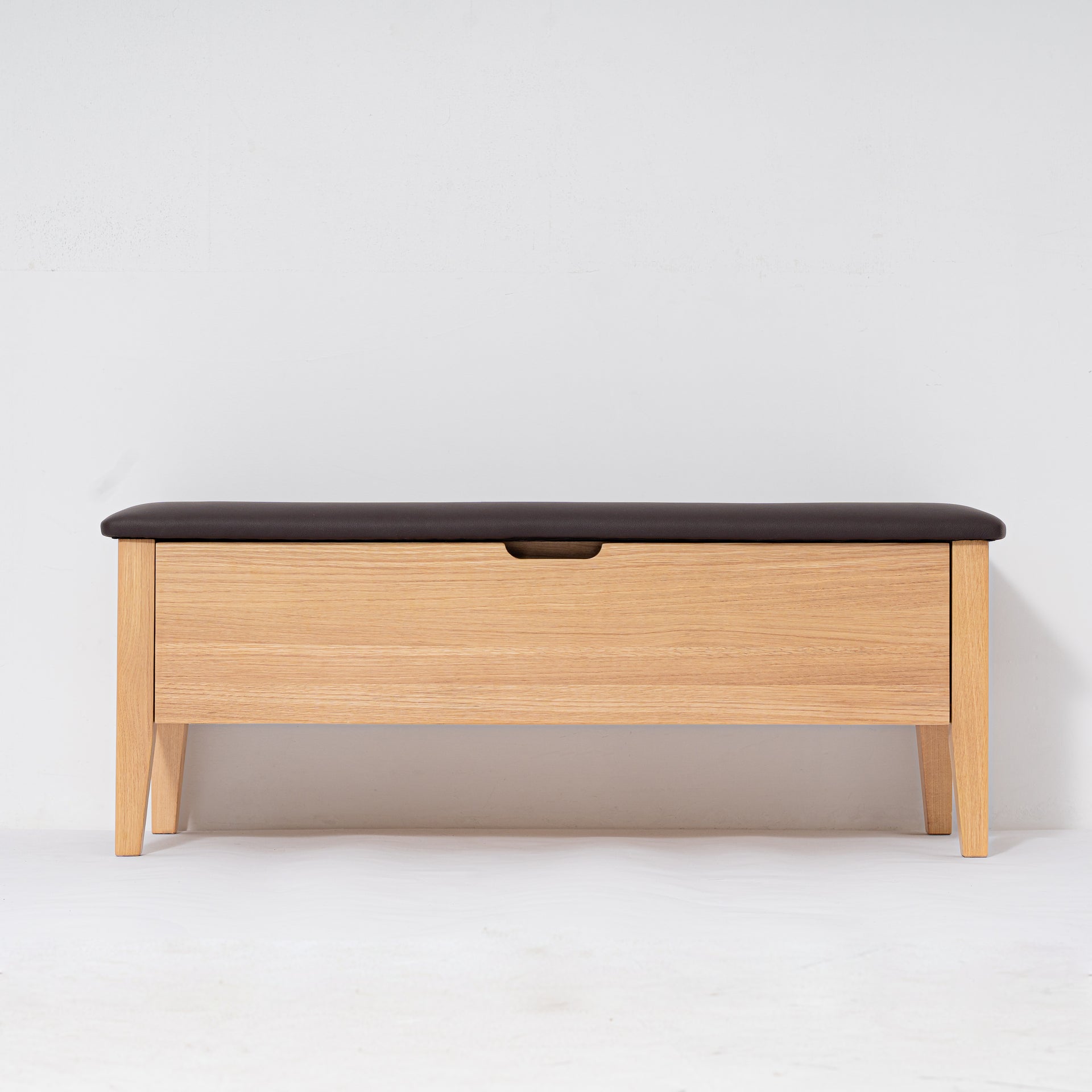 Wooden bench with a black cushion on a white background