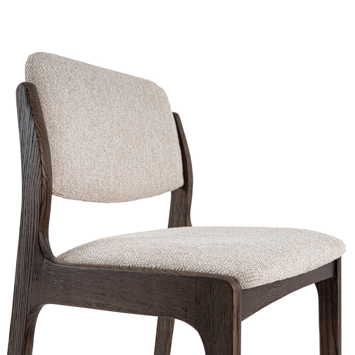 A modern wooden dining chair with a dark brown wood frame and textured beige fabric upholstery on the seat and curved backrest, shown against a plain white background.