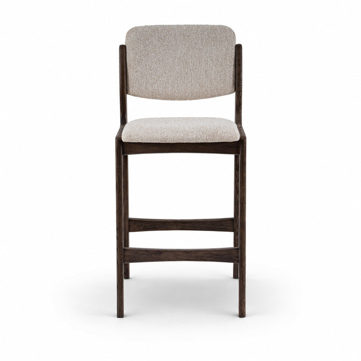 A modern barstool with a dark brown wooden frame and light beige textured fabric upholstery on the seat and backrest, shown against a plain white background.