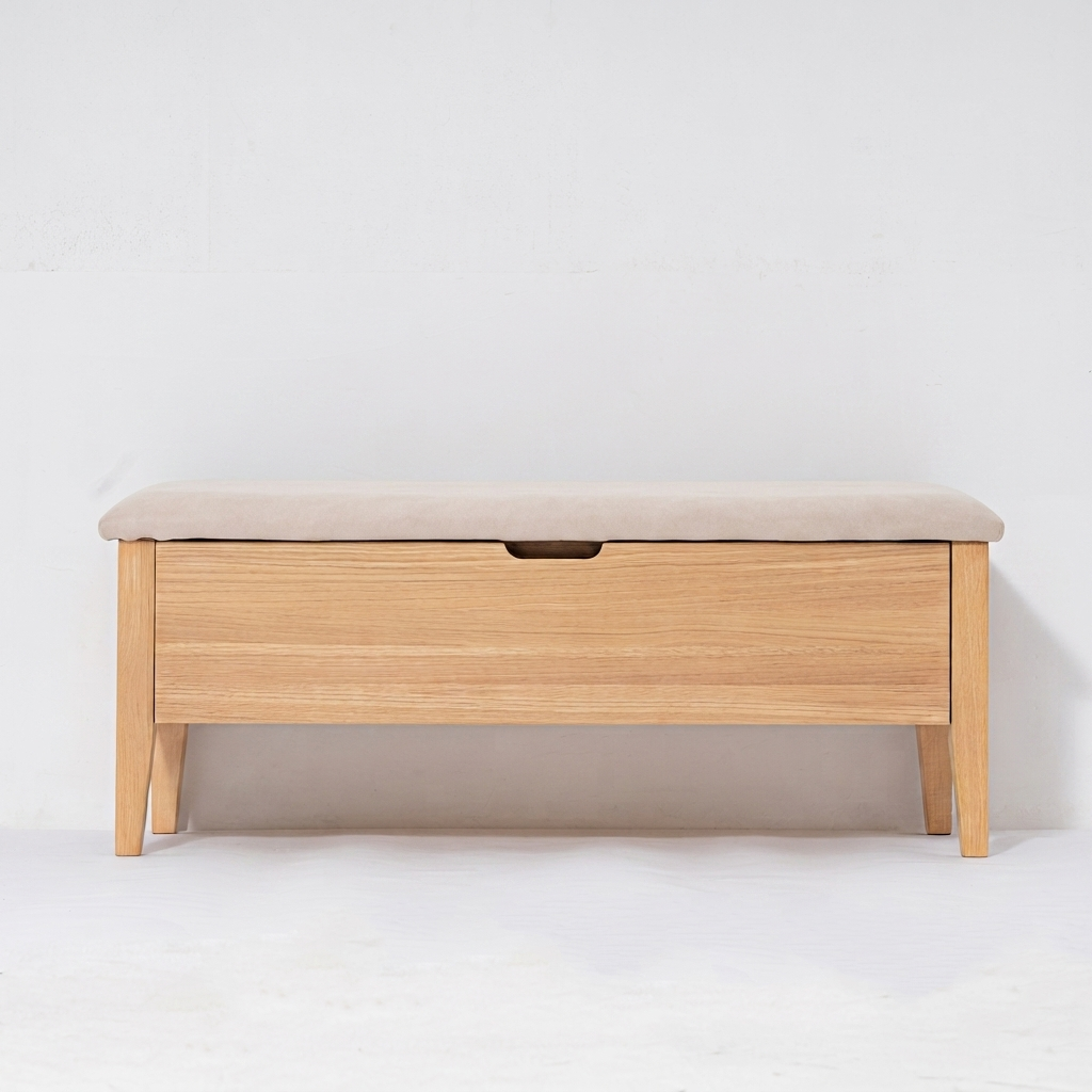 A light oak wood storage bench with a beige upholstered cushioned seat and a single front drawer featuring a dark metal pull handle, set against a plain white studio background.