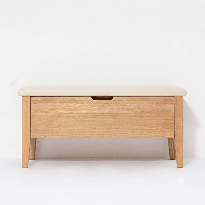A light oak wood storage bench with a cream-colored upholstered top and a single front drawer featuring a dark wood pull handle, set against a plain white background.