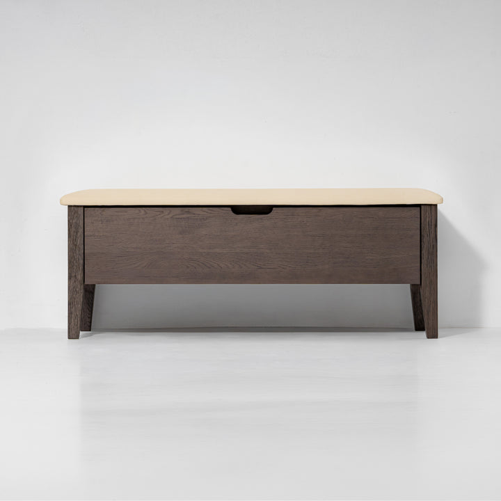 A modern wooden storage bench with a dark brown wood-grain frame and a light beige upholstered top, shown against a clean white studio background.