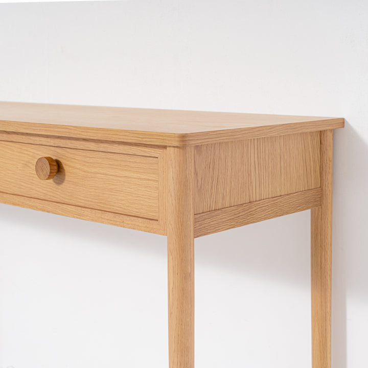 Wooden desk with a single drawer on a white background