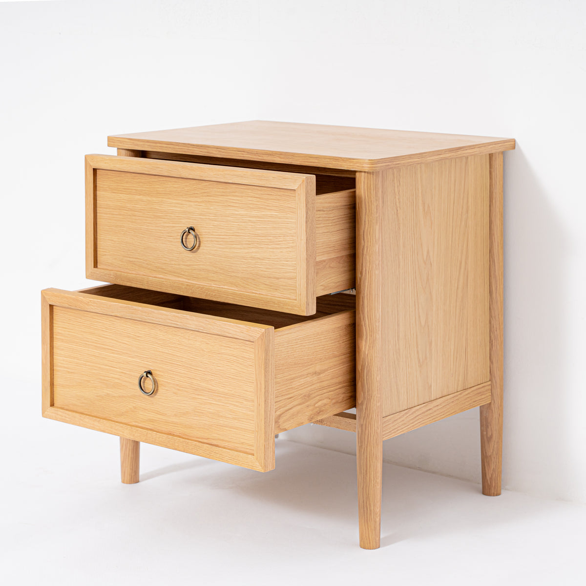 Wooden nightstand with two opened drawers on a white background