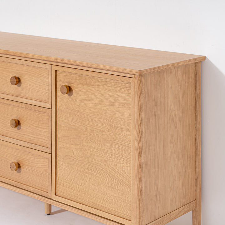 Wooden dresser with drawers and a door on a white background