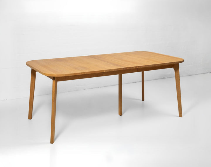 Handcrafted extendable oak dining table with warm wood tones and rustic texture