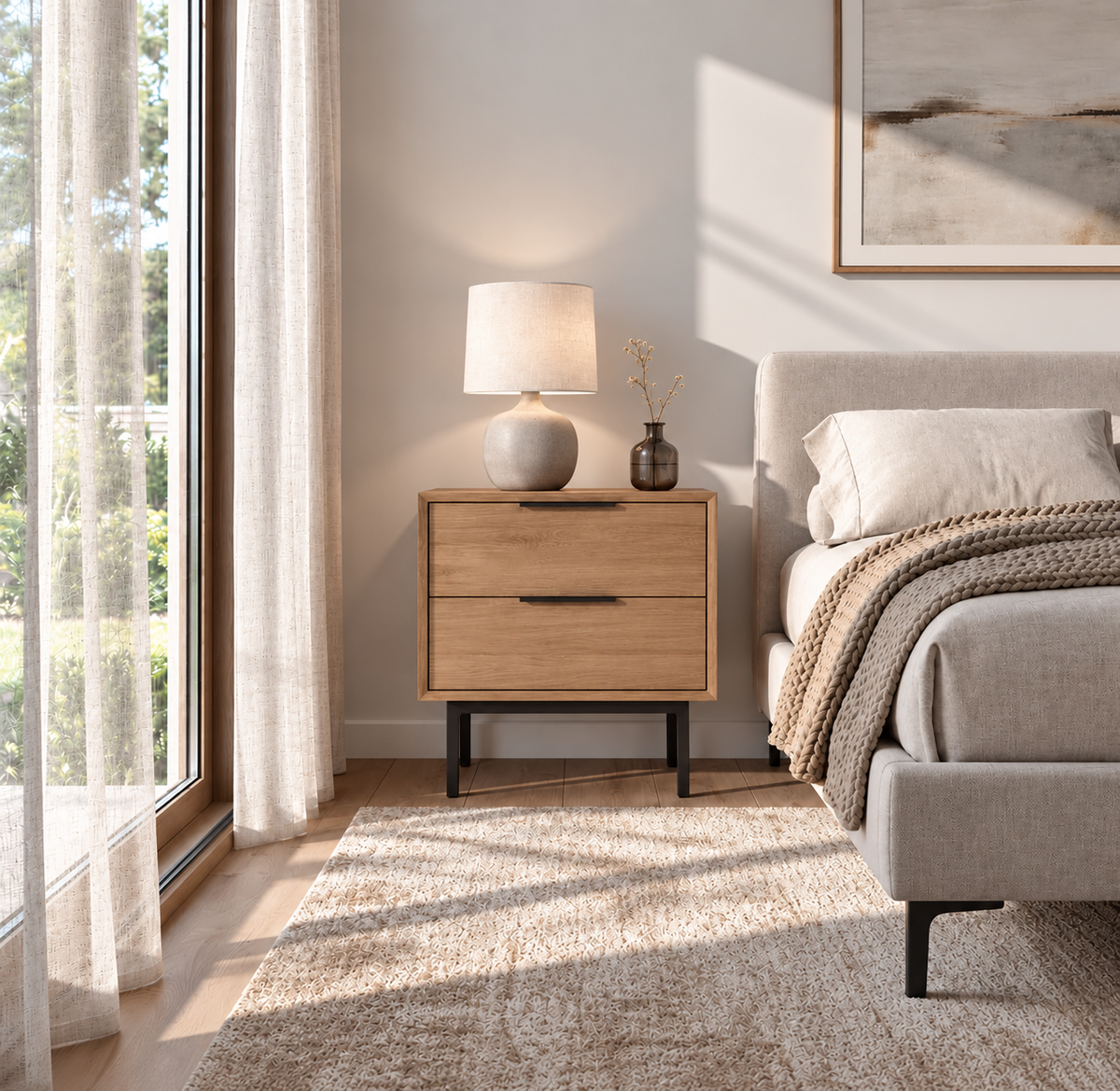 Bergen white oak nightstand with two drawers and black metal legs beside a bed in a bright bedroom