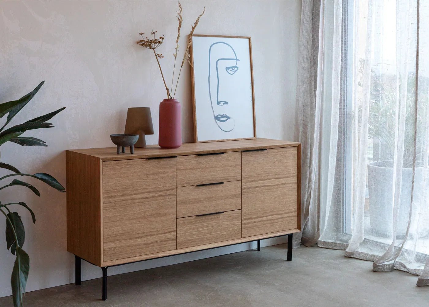 Modern oak dresser with slim black handles, natural wood grain, and minimalist silhouette
