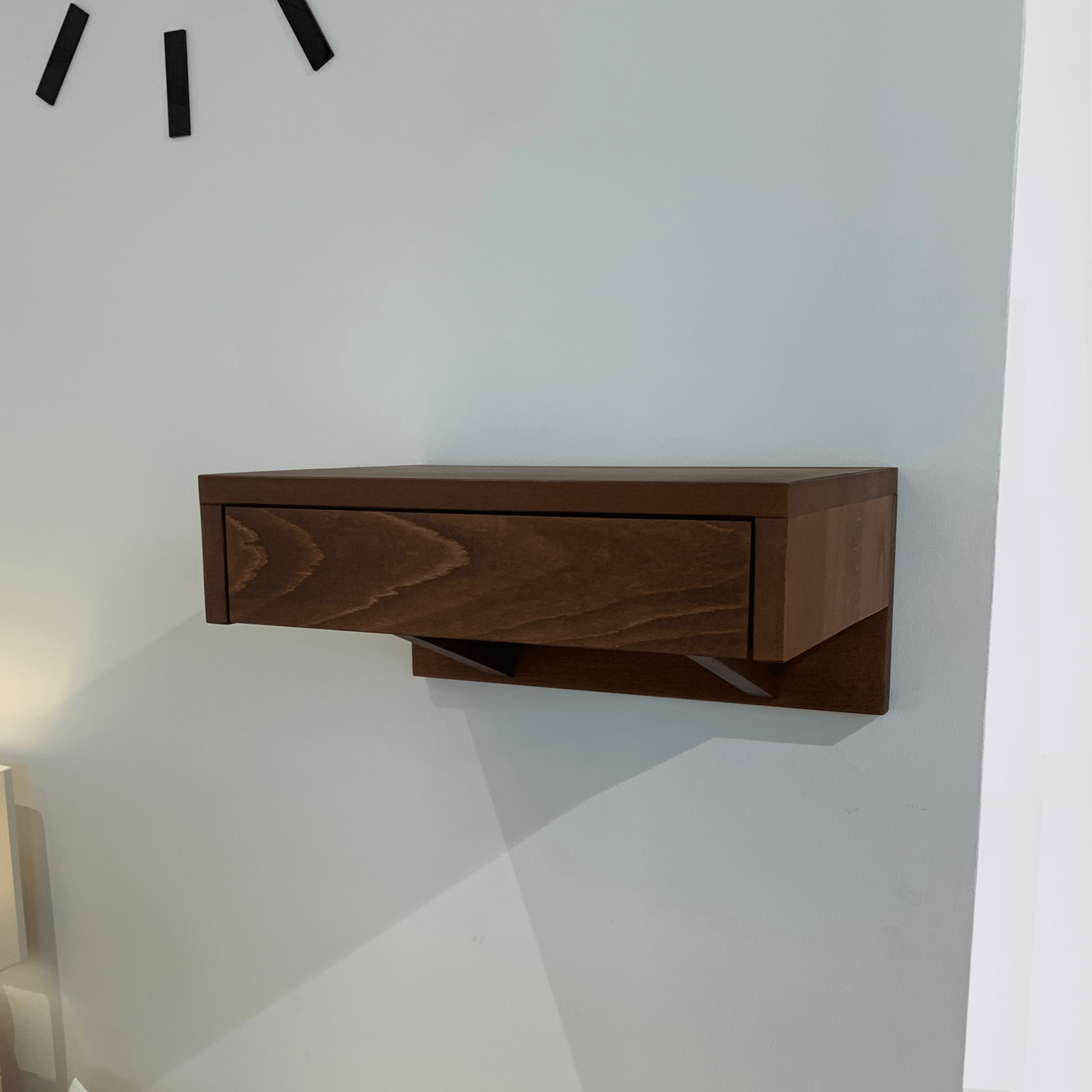 A wooden bedside table featuring a smooth drawer, seamlessly blending with modern bedroom interiors.