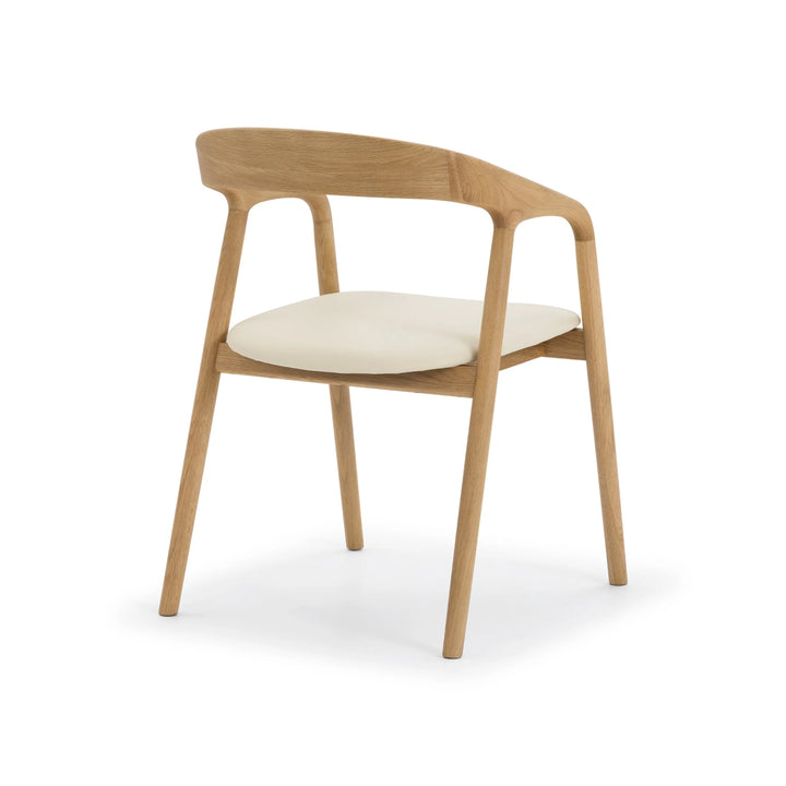 Celeste Oak Dining Chair angled front view showing solid oak frame construction, open armrest joints, and beige leather seat