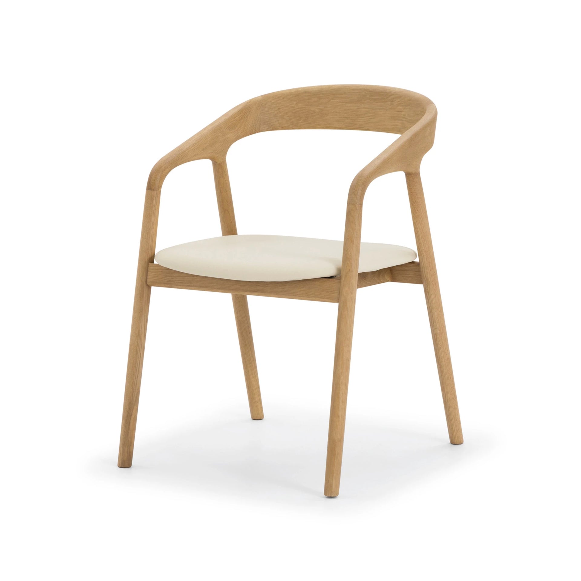 Celeste Oak Dining Chair angled three-quarter view showing curved backrest, solid oak armrests, and round beige leather seat