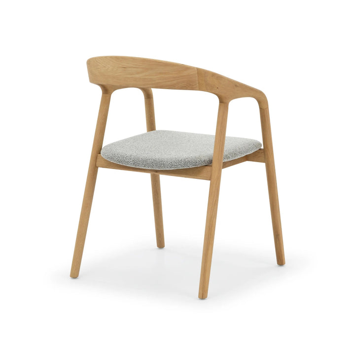 Celeste Oak Dining Chair rear three-quarter view on white background showing curved oak backrest panel, and Noel fabric seat