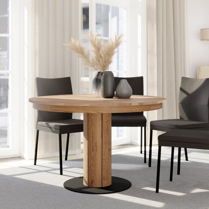 Handcrafted oak round dining table with extension feature and warm natural texture