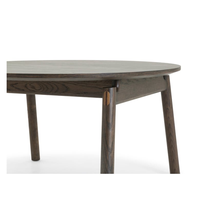 Espresso finished Oak Coffee Table Celeste close-up of round top and angled legs with contrasting wood joinery in minimalist solid oak design
