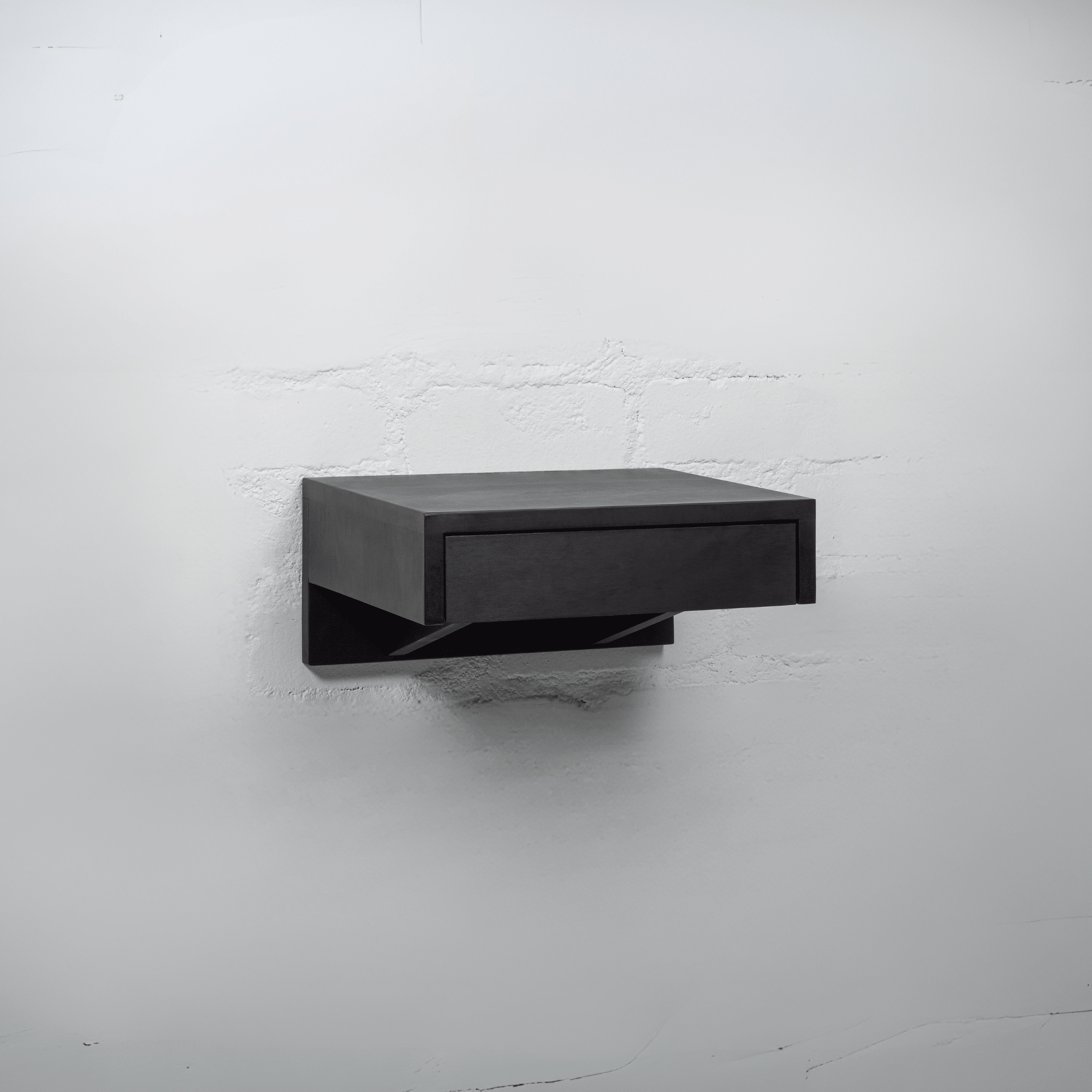 A black wooden nightstand with an open drawer revealing spacious storage for organizing bedroom essentials