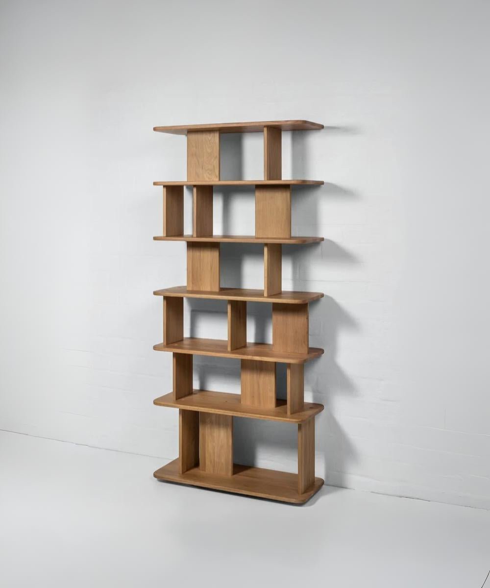 Modern oak bookcase with clean lines, dual-sided display, and flowing structure