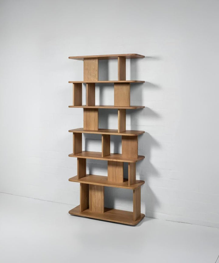 Modern oak bookcase with clean lines, dual-sided display, and flowing structure