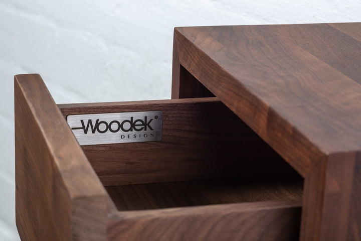 Close-up of Hugo Floating Nightstand open drawer interior showing Woodek Design brand plate and rich dark walnut wood grain