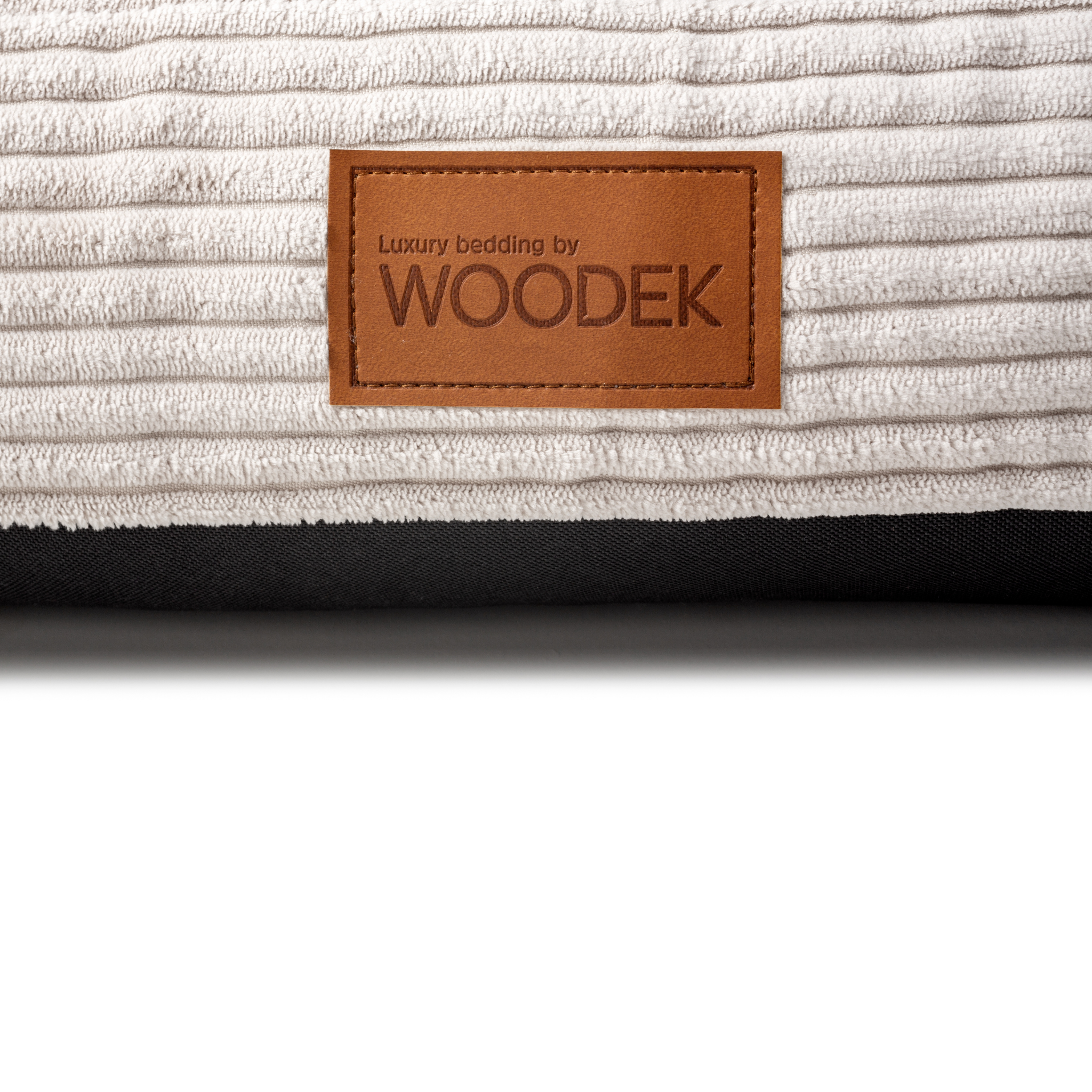 Close-up of a luxury beige pet mattress with a ribbed design, featuring the Woodek branding for high-quality bedding