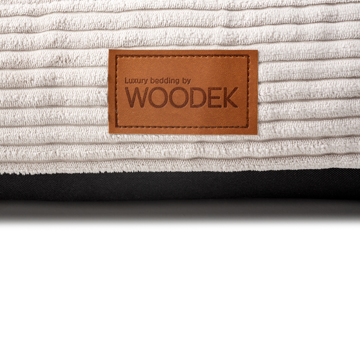 Close-up of a luxury beige pet mattress with a ribbed design, featuring the Woodek branding for high-quality bedding