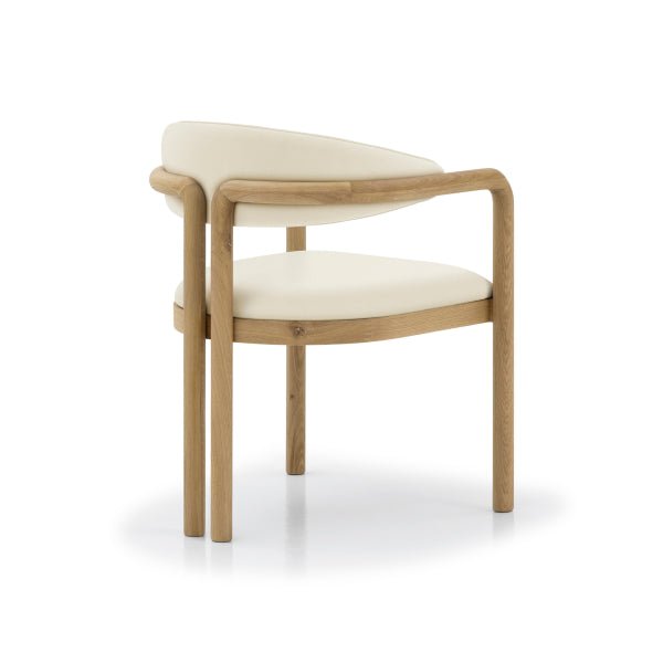 Nature Oak Dining Chair angled front view showing curved solid oak armrest rail and rounded beige leather backrest cushion