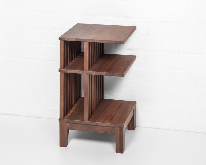 Handcrafted walnut bedside table with vertical slat design and sculptural tiered form