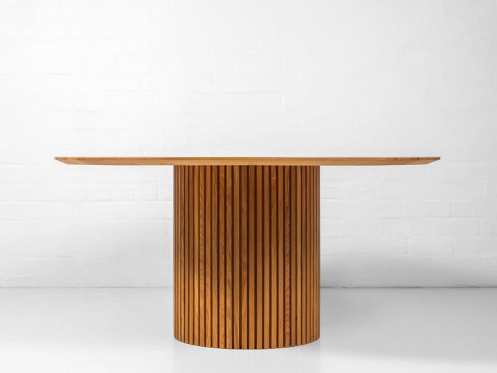 Solid oak circular dining table with natural grain patterns and artisanal craftsmanship