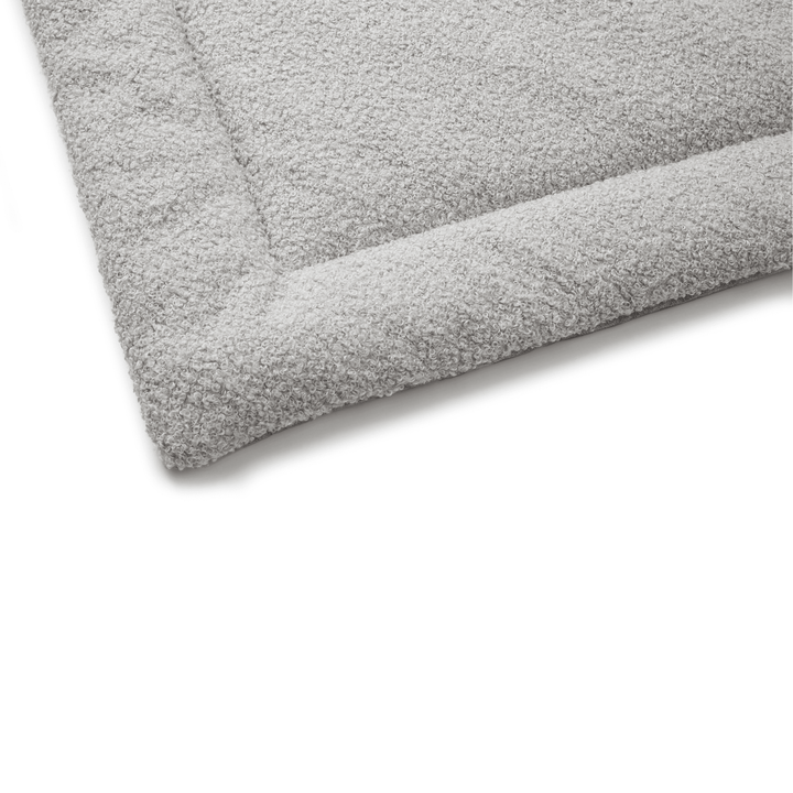 Close-up of a soft and durable gray bed with a textured surface for extra comfort.