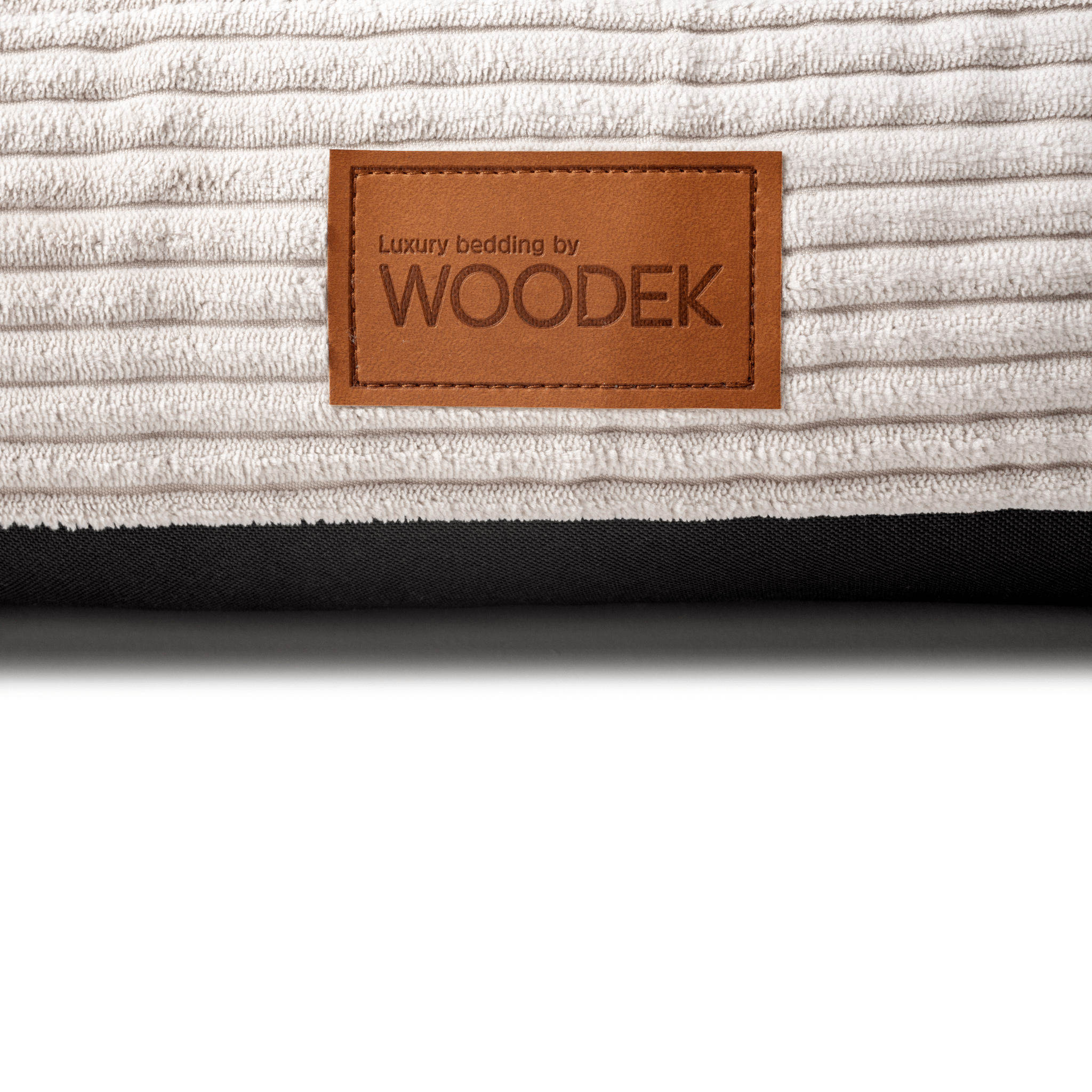 Close-up of a luxury beige pet mattress with a ribbed design, featuring the Woodek branding for high-quality bedding