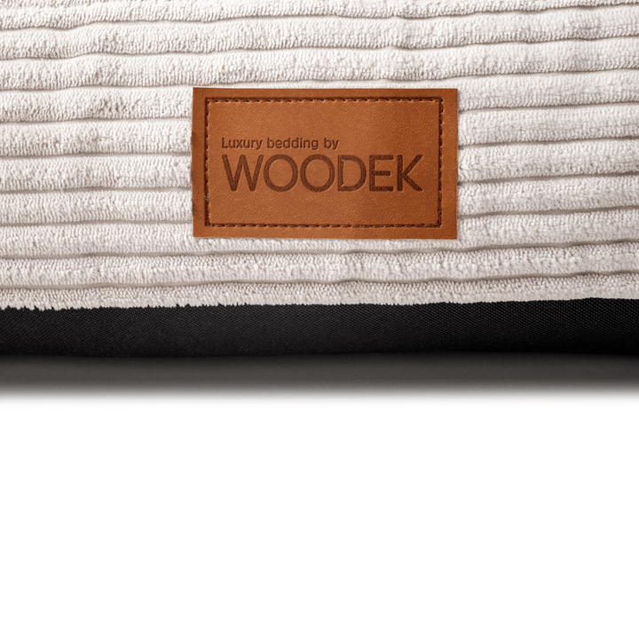 Close-up of a luxury beige pet mattress with a ribbed design, featuring the Woodek branding for high-quality bedding