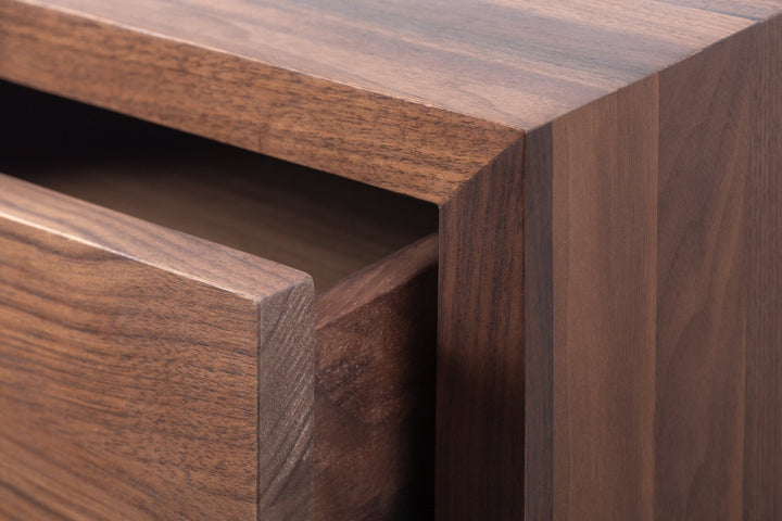 Macro close-up of Hugo Walnut Nightstand drawer edge showing deep walnut grain texture, push-to-open gap, and matte lacquer