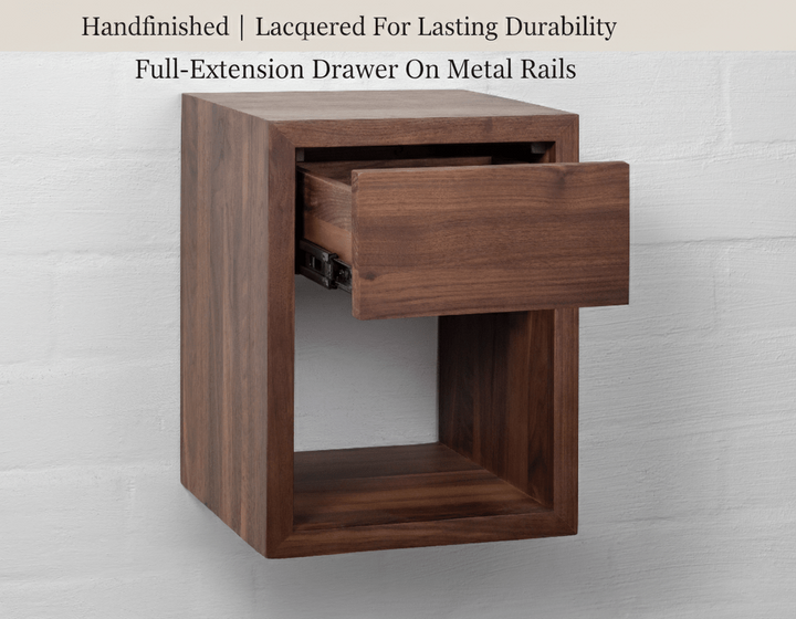 Wooden side table with a drawer on metal rails against a light gray background