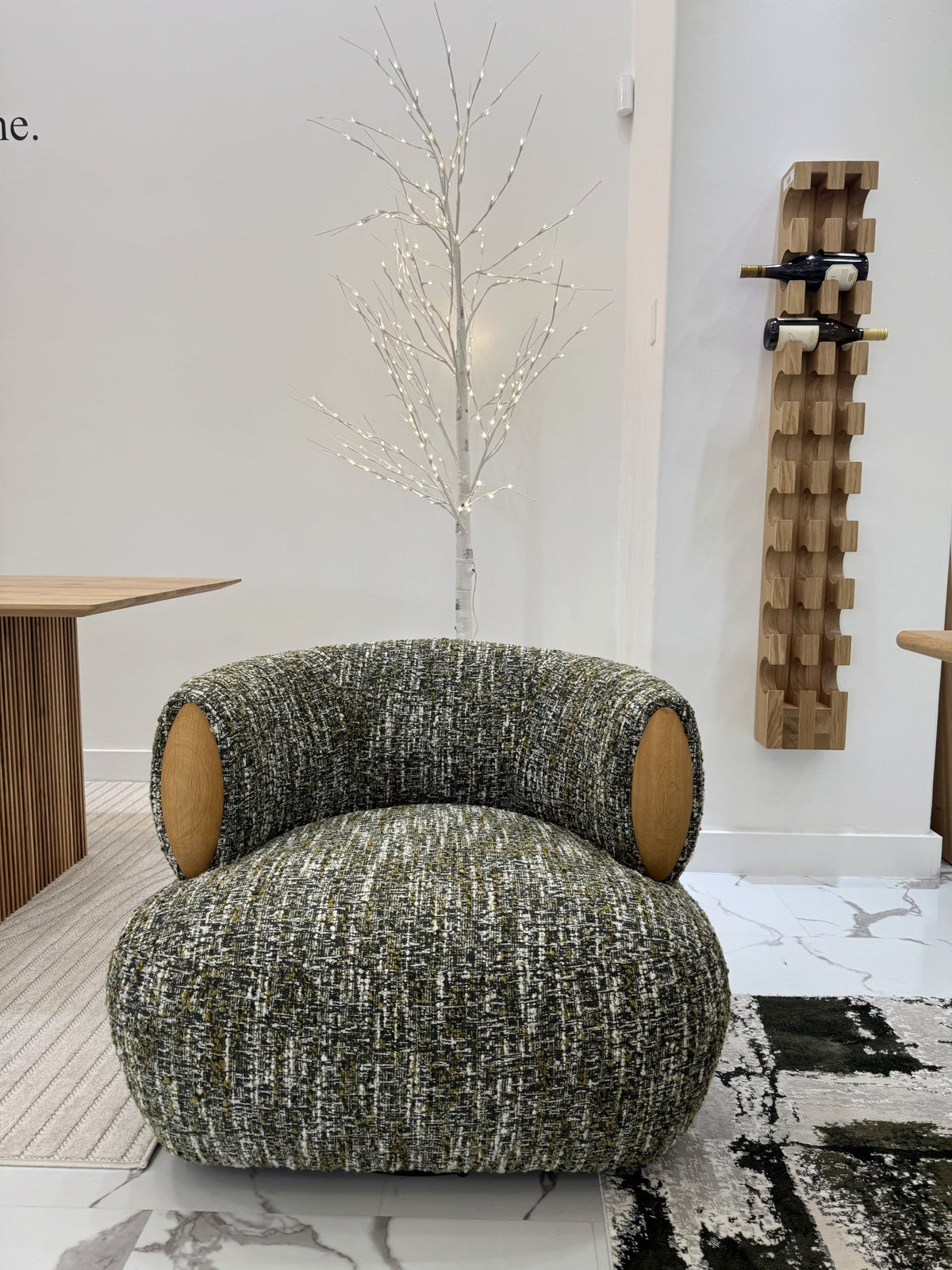 Theo – Swivel Armchair with Wooden Accents in textured green fabric with rounded shape and contrasting natural oak side details