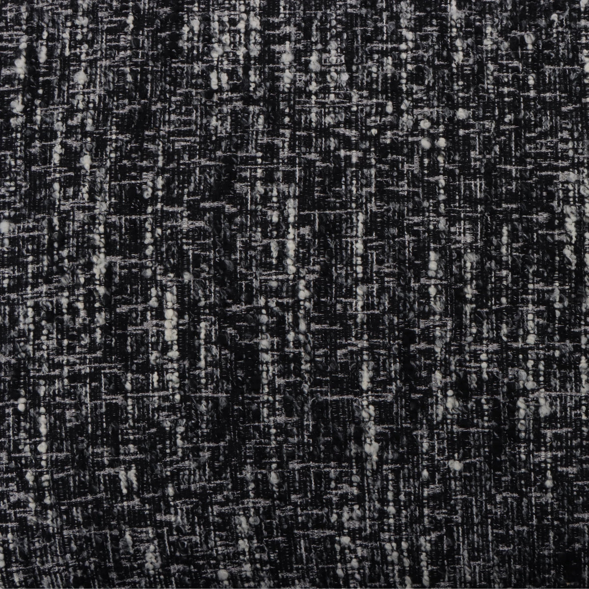 Tommy – Black Fabric Armchair with Oak Legs close-up on textured black-and-white fabric pattern