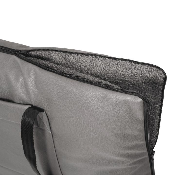A close-up of the Woodek 2-in-1 Dog Travel Bag & Mattress in grey, featuring a black handle, a soft textured inner lining, and a zippered design, shown partially open against a white background.